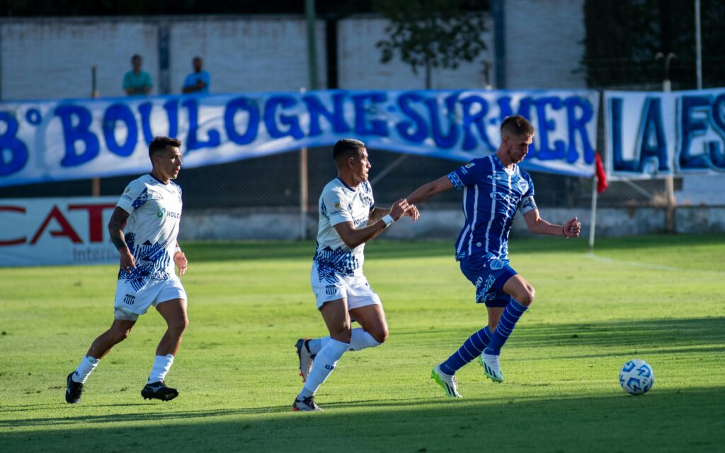 Soccer players in dynamic action on field during match, showcasing speed and skill.