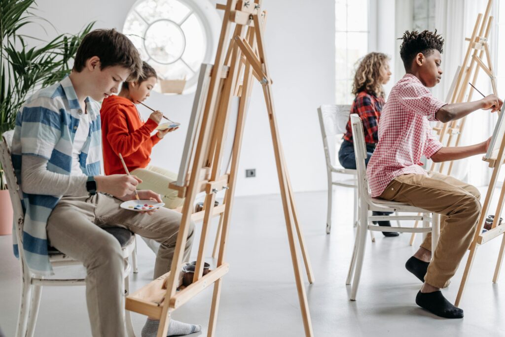 Children of diverse backgrounds focusing on painting in an art class, showcasing creativity.